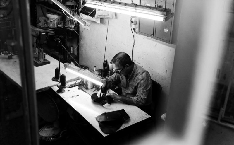 Couturier au travail sur sa machine dans l'atelier
