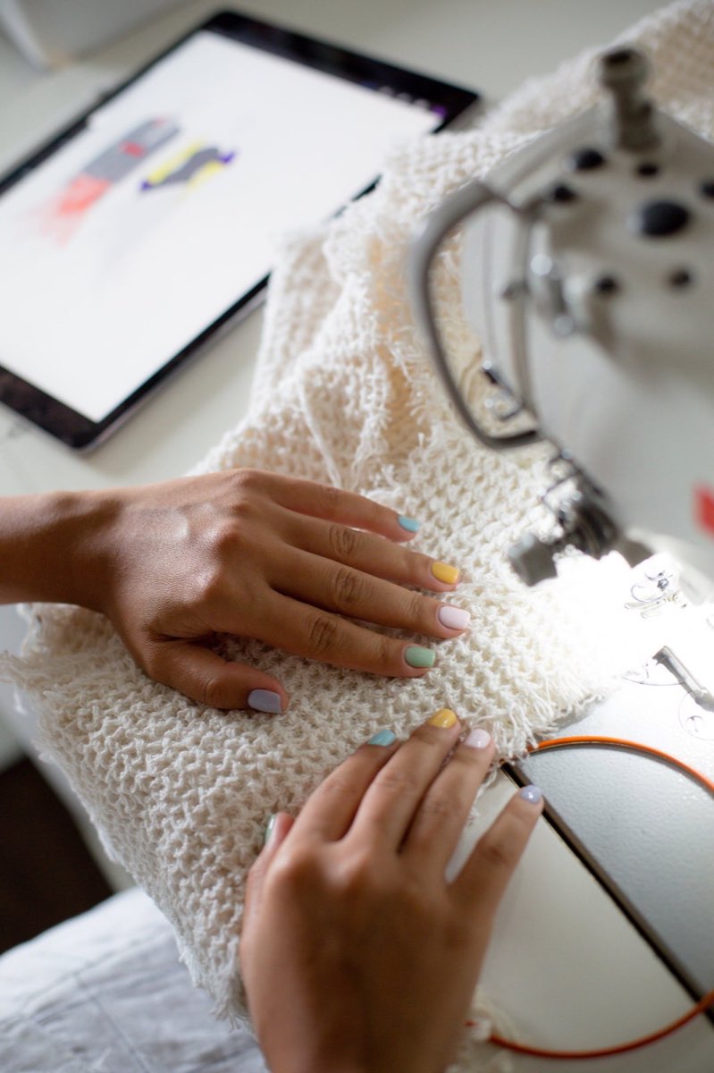 Mains guidant le tissu sous l'aiguille